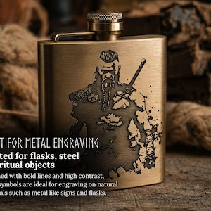 May include: A rectangular, brass-colored flask with a detailed engraved image of a Viking warrior holding a sword. The flask has a screw-on cap and a hinged top. Text on the image reads "BUILT FOR METAL ENGRAVING" and "Crafted for flasks, steel and ritual objects."