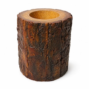 May include: A cylindrical wooden container with a hollowed-out interior. The exterior has a rough, textured bark-like appearance in shades of brown and dark brown. The interior is a lighter shade of brown.