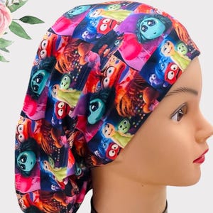 May include: A colorful surgical scrub hat with a pattern of characters from the movie Inside Out. The hat is made of a soft, breathable fabric and is designed to be comfortable to wear for long periods of time.