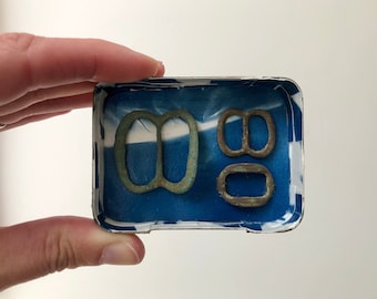 Found object art, collection of historic buckles, unique wall hanging, cyanotype, mixed media, altered tin