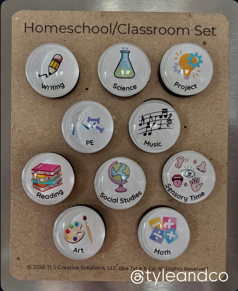May include: A set of nine round magnets with various school subject illustrations, including writing, science, and art. The text "Homeschool/Classroom Set" is at the top. The magnets are on a brown background.