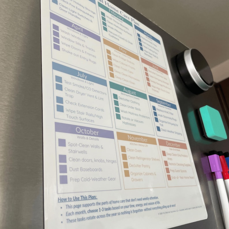May include: A magnetic home care plan on a fridge door. The plan is a colourful checklist with monthly tasks, including cleaning windows, dusting, and decluttering. A black magnetic button and a green eraser are attached.