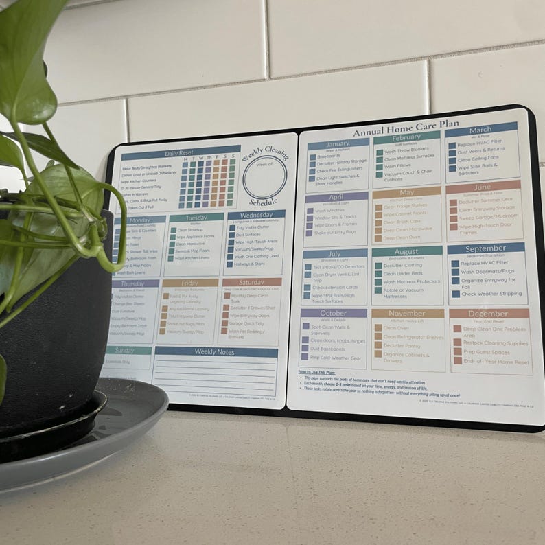 May include: A black and white home care planner with a weekly and monthly schedule. The planner includes sections for daily, weekly, and monthly tasks. The text on the planner includes the words "Weekly Cleaning Schedule" and "Annual Home Care Plan".