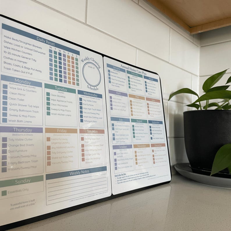 May include: A black and white cleaning schedule with sections for daily, weekly, and annual tasks. The schedule includes a daily reset checklist and a weekly cleaning schedule. A potted plant sits to the right.