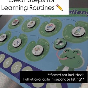 May include: A blue educational board game with the text "Clear Steps for Learning Routines." The game features circular magnets with subject icons like math and science, placed on lily pads. A cartoon frog is on the right side of the board.