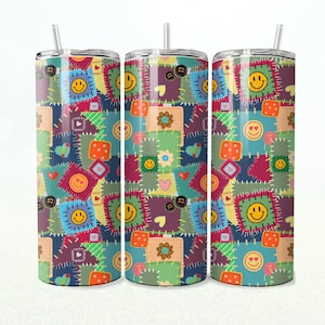 Op de afbeelding: Drie roestvrijstalen bekers met een patchwork-ontwerp met lachende gezichten, harten en knopen. De bekers zijn allemaal even groot en hebben een rietje.