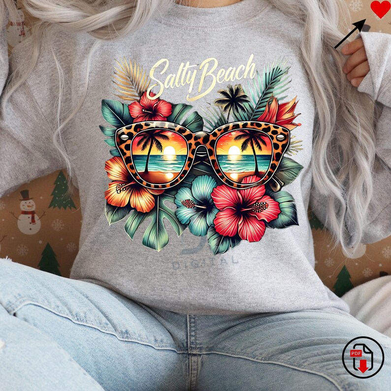May include: A gray sweatshirt with the text "Salty Beach" and a pair of sunglasses with a tropical beach scene reflected in the lenses. The sunglasses are surrounded by tropical flowers and leaves.
