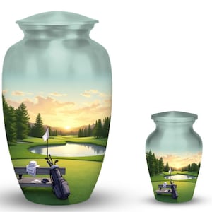Può includere: Due urne azzurre con una scena di campo da golf. L'urna più grande raffigura un campo da golf con uno stagno, alberi e un tramonto. L'urna più piccola ha lo stesso design. Le urne sono probabilmente per conservare resti cremati.