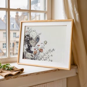 May include: A framed illustration of a robot with a white head and a metallic body, surrounded by delicate flowers in shades of pink, yellow, and orange. The robot appears to be interacting with the flowers, creating a whimsical and surreal scene.