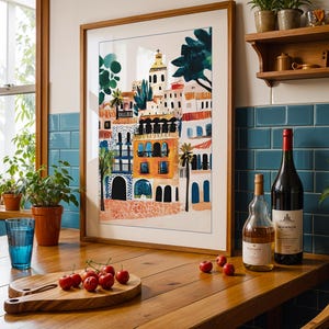 May include: A framed illustration of a colourful cityscape with buildings, palm trees, and a church steeple. The illustration is on a white background and is framed in a natural wood frame. The frame is sitting on a wooden table with a glass of water, a chopping board with cherries, and two bottles of wine.