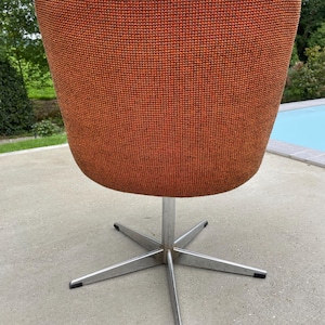 Peut inclure: Une chaise pivotante avec une base en &eacute;toile et un rev&ecirc;tement en tissu orange.