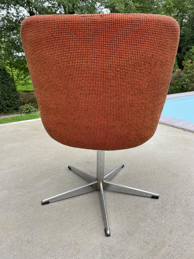 Peut inclure: Une chaise pivotante avec une base en &eacute;toile et un rev&ecirc;tement en tissu orange.