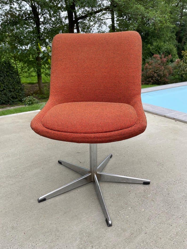 Peut inclure: Une chaise pivotante avec une base en &eacute;toile et un rev&ecirc;tement en tissu orange.