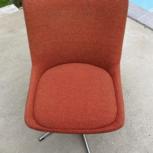 Peut inclure: Une chaise pivotante rouge avec un rev&ecirc;tement en tissu &agrave; motifs et une base chrom&eacute;e.