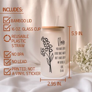 May include: A frosted glass cup with a bamboo lid and a reusable plastic straw. The cup is 5.9 inches tall and 2.95 inches wide. It features a black and white floral design with the text "Nana You have loved me ever since I was born but I have loved you my entire life Love, Evan".