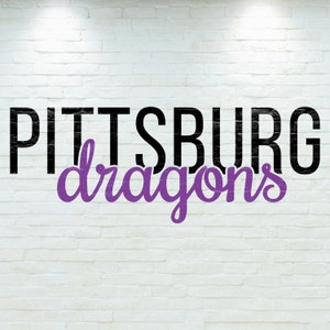 May include: Black and white text on a white brick wall reads "PITTSBURG dragons" in a purple cursive font.