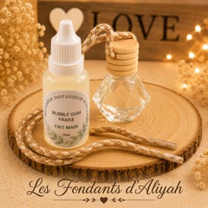 May include: A clear glass car air freshener and a refill bottle with a white cap and a label that reads "Bubble Gum Fraise". The items are on a wooden slice with a rope and the text "Les Fondants d'Aliyah".