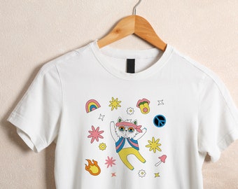 May include: White t-shirt with a cartoon cat wearing sunglasses and a bandana, surrounded by colorful peace signs, flowers, and a rainbow.