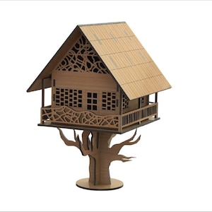Puede incluir: Un modelo de casa de árbol de madera con un techo marrón y detalles intrincados cortados con láser. La casa del árbol tiene un balcón y está posada sobre un tronco de árbol de madera.