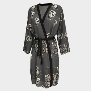 May include: A black and grey kimono robe with a skull and crossbones pattern. The robe has a black sash and is made of a lightweight fabric.