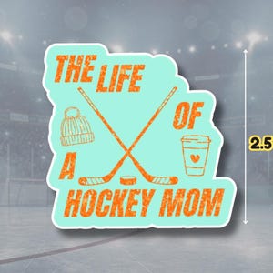 May include: A sticker with the text "THE LIFE OF A HOCKEY MOM" in orange, with a teal background. The sticker is 2.5 inches in height and features hockey sticks, a hat, and a coffee cup.