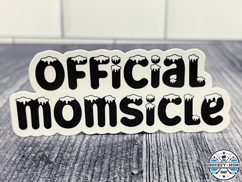 May include: Black and white sticker with the text "Official Momsicle" in a stylized font with white icicles on top of each letter.