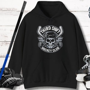 May include: Black hoodie with a white graphic of a hockey stick skull with the text "Third Shift Hockey Club".
