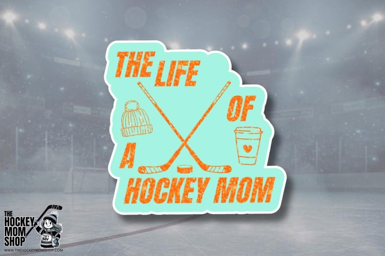 May include: A teal sticker with the text "THE LIFE OF A HOCKEY MOM" in orange, featuring crossed hockey sticks, a beanie, and a coffee cup. The sticker is set against a blurred hockey rink background.