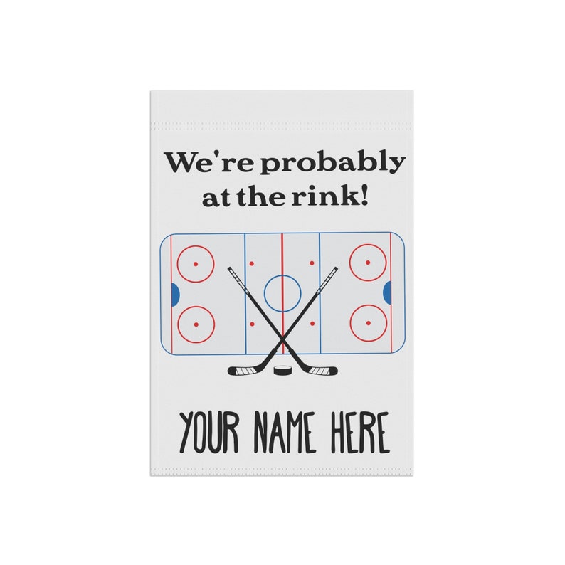 K&ouml;nnte beinhalten: Eine wei&szlig;e Gartenflagge mit einem Eishockeyfeld und zwei gekreuzten Schl&auml;gern. Der Text "We're probably at the rink!" befindet sich &uuml;ber dem Feld und "YOUR NAME HERE" darunter.