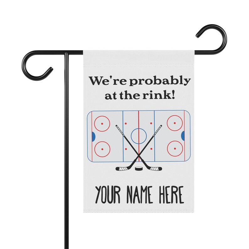 K&ouml;nnte beinhalten: Eine wei&szlig;e Gartenflagge mit einem Hockeyfeld und Schl&auml;gern, dem Text "We're probably at the rink!" und dem Text "YOUR NAME HERE".