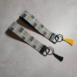 These are wristlet keychains made of faux leather and designed for 911 dispatchers and call-takers. They feature a thin gold line.