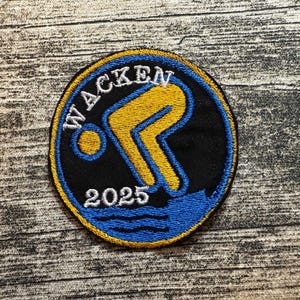 May include: Embroidered patch with the word "WACKEN" in white, arched across the top of a black circle. A yellow and blue figure dives into blue water, with the year "2025" below. The patch has a gold border.
