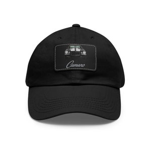May include: Black baseball cap with a white patch featuring a black and white image of a classic Camaro with the word "Camaro" in white text.