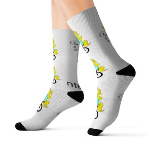 May include: White socks with a repeating pattern of a blue unicorn riding a bicycle with yellow hair and a crown. The text "inte" is printed on the socks.