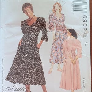 May include: McCall's sewing pattern featuring three dress designs. The cover shows illustrations of the dresses, including a black and white floral print dress, a floral print dress, and a solid pink dress. Size 14.