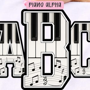 May include: White t-shirt with the letters "A", "B", and "C" in a piano key design. The letters are outlined in black and filled with piano keys and musical notes. The text "PIANO ALPHA" is on a pink label.