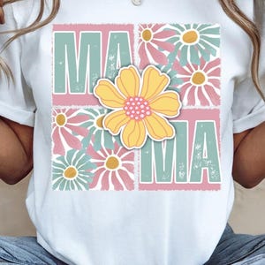 May include: White t-shirt with a floral design and the word "MAMA" in a vintage style font.