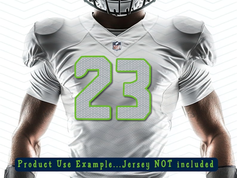 Puede incluir: Camiseta de f&uacute;tbol americano blanca con el n&uacute;mero 23 en un patr&oacute;n de punto gris con contorno verde. La camiseta tiene el logo de la NFL y hombreras. El texto en la parte inferior dice "Product Use Example...Jersey NOT included."