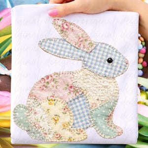 May include: A patchwork bunny design in pastel shades, featuring floral and gingham patterns. The bunny incorporates pink, blue, yellow, and green fabrics, with a black button eye and lace detailing. The design is set against a white backdrop.