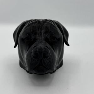 Könnte beinhalten: Eine schwarze, 3D-gedruckte Skulptur eines Hundekopfes. Die Skulptur weist detaillierte Gesichtszüge auf, darunter eine markante Nase, Schlappohren und eine strukturierte Oberfläche. Der Hundekopf ist vor einem schlichten weißen Hintergrund zentriert.
