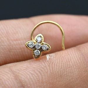 May include: A gold nose ring with a flower design featuring five small diamonds.