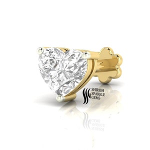 May include: A gold nose ring with a heart-shaped diamond. The diamond is set in a prong setting and has a clear, brilliant cut. The nose ring is made of 14k gold and is available in a variety of sizes.
