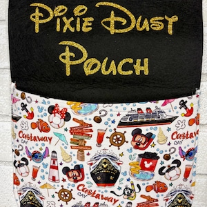 May include: A black felt hanging pouch with gold glitter text reading Pixie Dust Pouch. The lower pocket features a white fabric printed with colorful Disney cruise ship icons, Castaway Cay signs, lighthouses, anchors, and cartoon characters.
