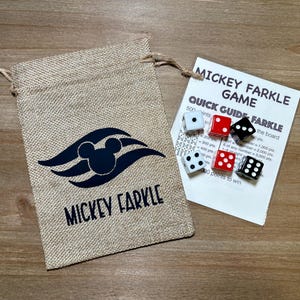 May include: A burlap bag with a Mickey Mouse design and the words "Mickey Farkle" printed in black. Next to it is a quick guide for the Mickey Farkle game and six dice, with white, red, and black colors.