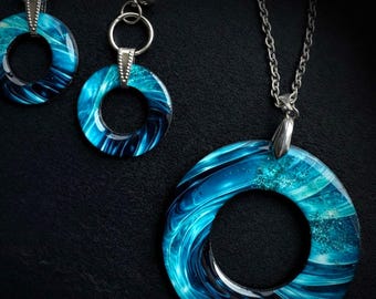 Conjunto de joyas de resina azul, collar y pendientes llamativos.