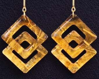 Pendientes geométricos modernos con diseño cuadrado en capas y brillo cálido