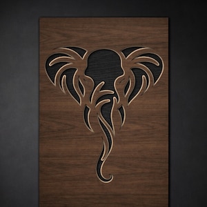 Op de afbeelding: Houten wandkunst met een olifantenontwerp. De olifant is uit het hout gesneden, met een donkere achtergrond die door de negatieve ruimte zichtbaar is. Het hout heeft een warme, bruine tint.
