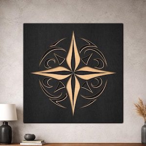 May include: A square wall art piece featuring a black wooden panel with a centred, light-coloured wood inlay. The inlay displays a symmetrical, four-pointed star design surrounded by intricate, curved, and geometric cut-out patterns.