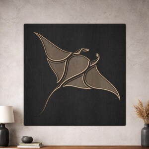 Op de afbeelding: Een houten wandkunstwerk met een gestileerd manta rog ontwerp. De manta rog is afgebeeld in tinten bruin en goud tegen een donkere, getextureerde achtergrond. Het kunstwerk is gemonteerd op een vierkant houten paneel.