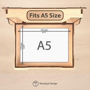 May include: A light brown wooden A5 display box. The box is open, showing a white A5 sheet with dimensions of 233 mm by 173 mm (9.17" x 6.81"). The text "Fits A5 Size" is displayed on the top of the box.